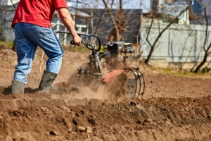 Man working in the garden with Garden Tiller. | Base Camp Country